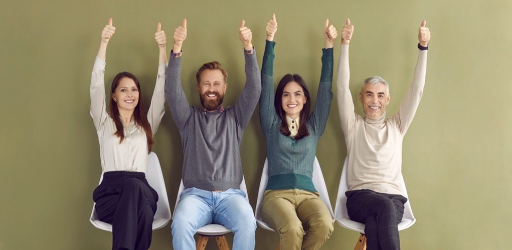 Portrait,Of,Four,Happy,Satisfied,People,Sitting,In,Row,With