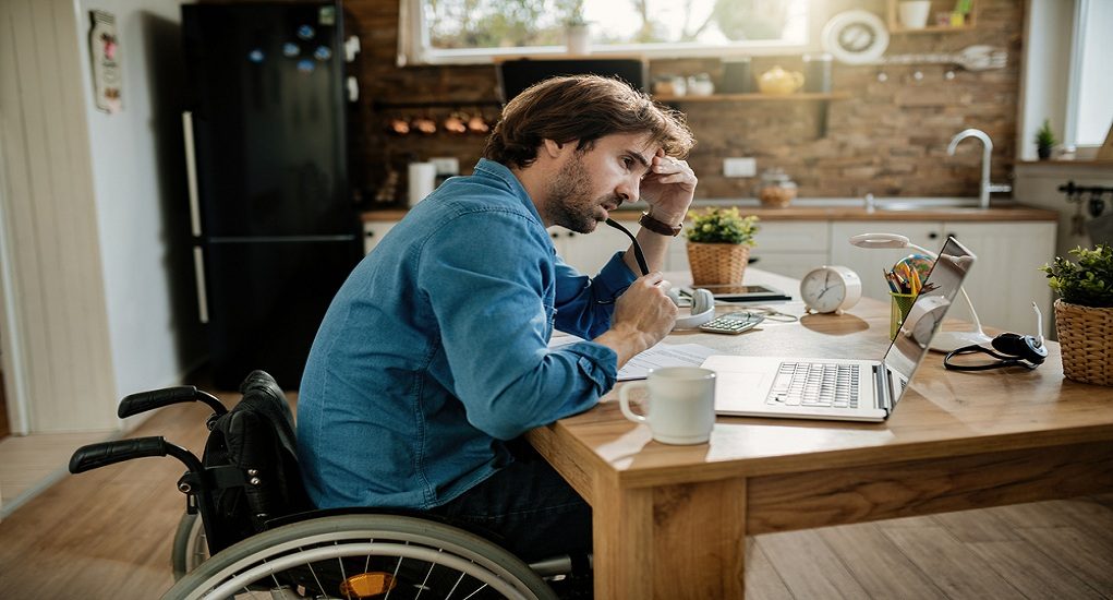 Pensive,Freelance,Worker,In,Wheelchair,Reading,Problematic,E-mail,On,Laptop