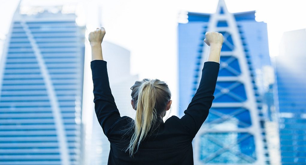 Business,Success,-,Celebrating,Businesswoman,Overlooking,The,City,Center,High-rises.