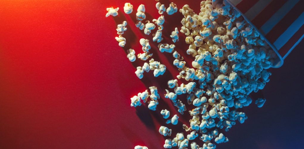 Spilled,Popcorn,On,A,Red,Background,,Cinema,,Movies,And,Entertainment