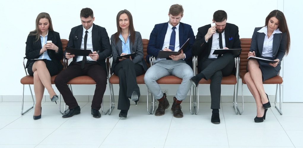 Business,Team,With,Clipboards,Sitting,In,A,Row