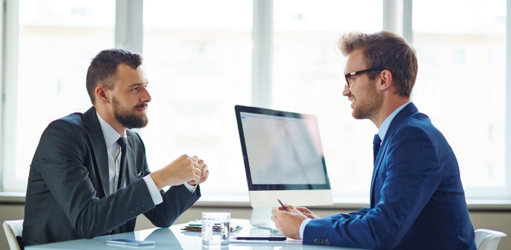 Confident,Businessmen,Sitting,By,Table,During,Consultation