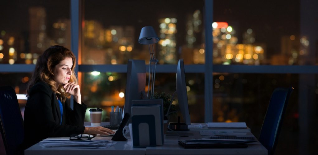 Pretty,Business,Woman,Working,Alone,In,Dark,Office